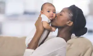 Mmother kissing baby thankful for understand australian standards and ecxtended rear facing