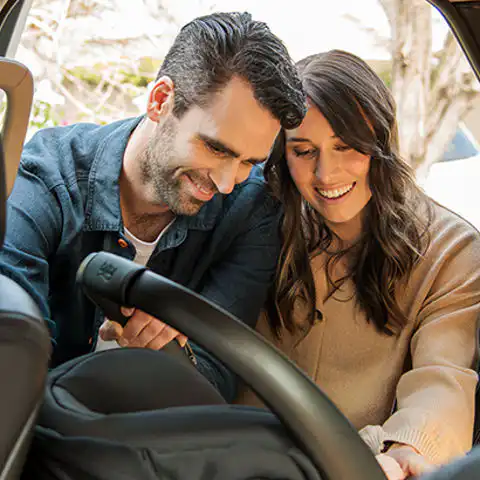 Happy parents with baby capsule in melbourne